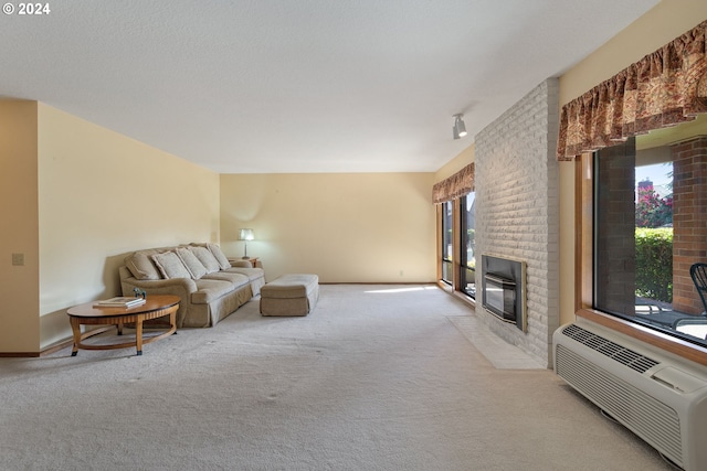 carpeted living area with a wall unit AC, a brick fireplace, and baseboards