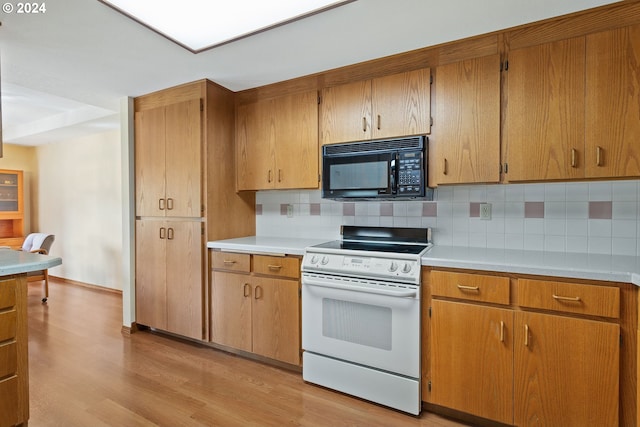 kitchen with light countertops, white electric range, light wood-style flooring, backsplash, and black microwave