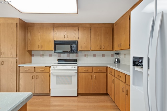 kitchen with light wood-style floors, white appliances, light countertops, and tasteful backsplash