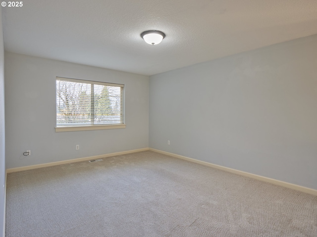 carpeted spare room featuring a textured ceiling