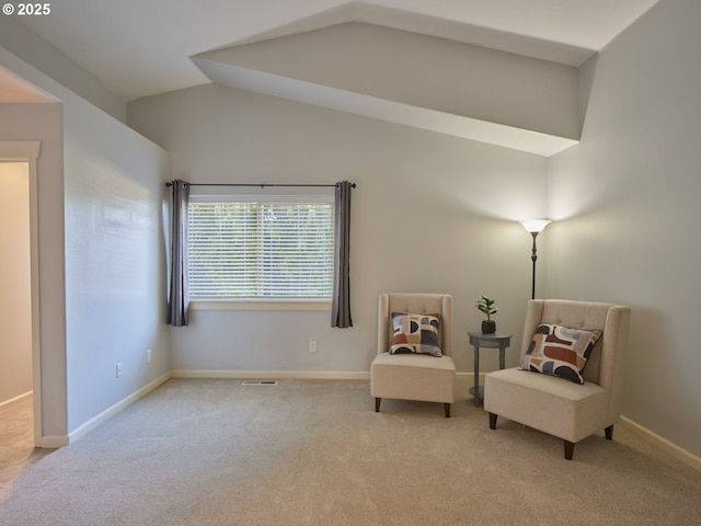 living area with lofted ceiling and light colored carpet