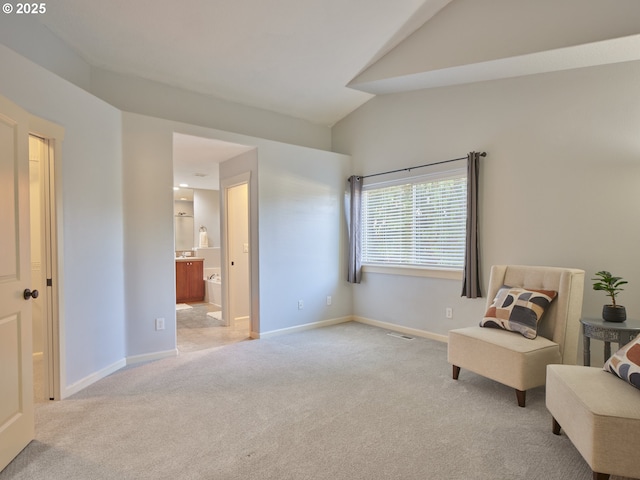 sitting room with lofted ceiling and light colored carpet