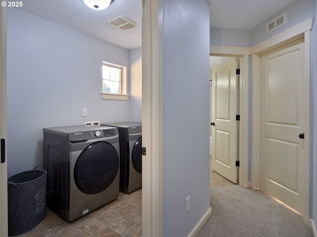 laundry room with light colored carpet and separate washer and dryer