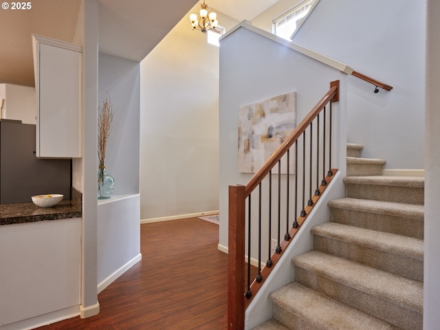 staircase with a chandelier and hardwood / wood-style floors