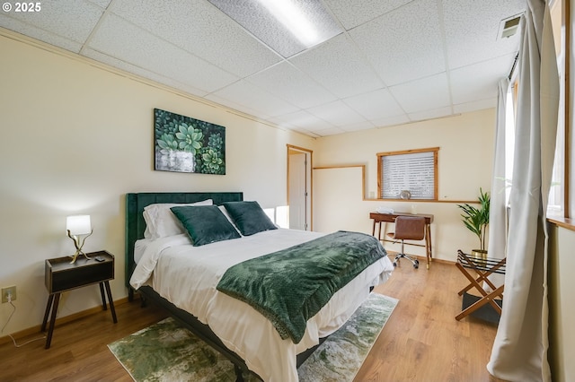 bedroom featuring a paneled ceiling and light wood-type flooring