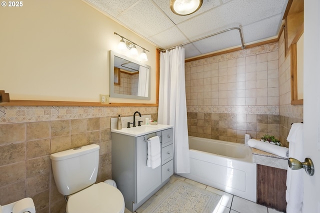 full bathroom with toilet, tile walls, vanity, shower / bath combo, and tile patterned flooring