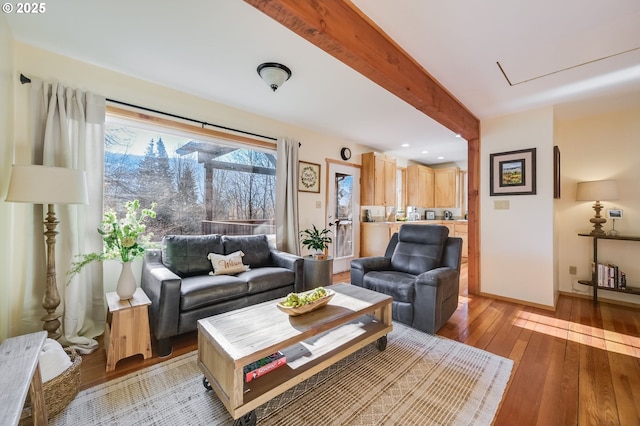 living room featuring beamed ceiling and light wood-type flooring