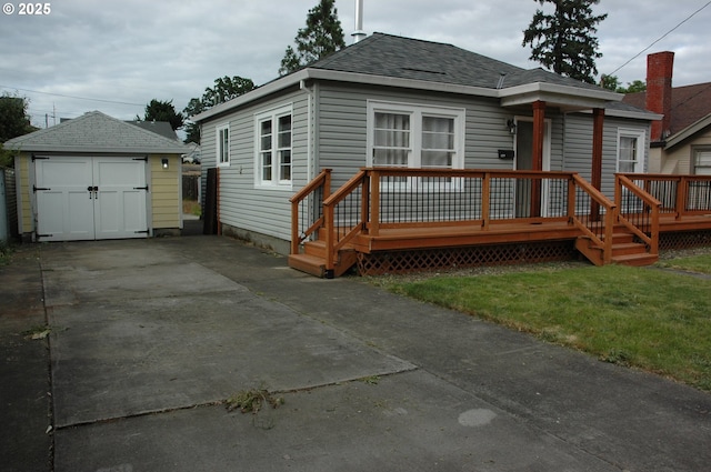 124 S 20th St, Saint Helens, OR 97051 - back of house featuring an outbuilding, a garage, driveway, a shingled roof, and a deck