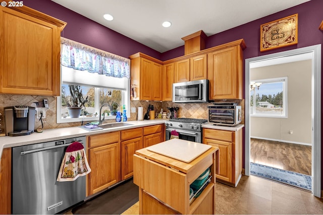 kitchen with a toaster, recessed lighting, a sink, decorative backsplash, and stainless steel appliances