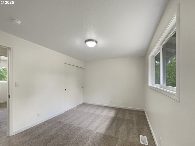 carpeted empty room with baseboards and visible vents