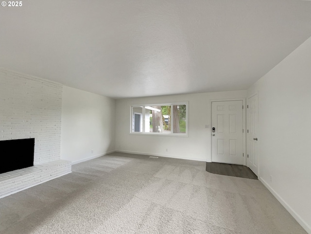 unfurnished living room featuring a fireplace, baseboards, and carpet