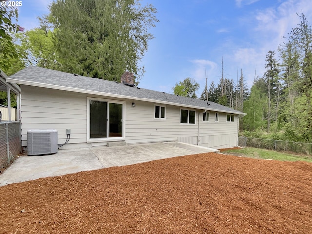 back of house featuring central air condition unit, fence, a chimney, and a patio area
