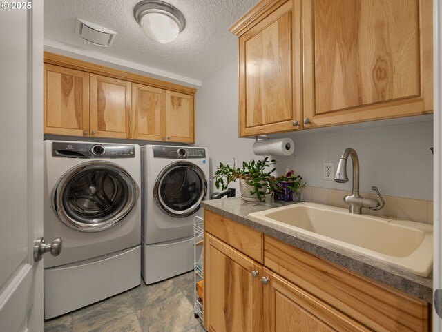 25210 E Arrah Wanna Blvd, Welches, OR 97067 - laundry area featuring washer and clothes dryer, cabinet space, a textured ceiling, and stone finish floors