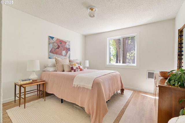 12620 NW Barnes Rd, Portland, OR 97229 - bedroom featuring light wood-style floors and a textured ceiling