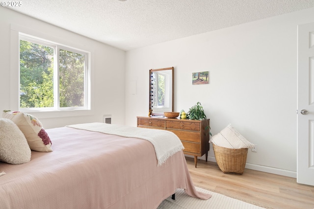 12620 NW Barnes Rd, Portland, OR 97229 - bedroom featuring light wood-style floors and a textured ceiling