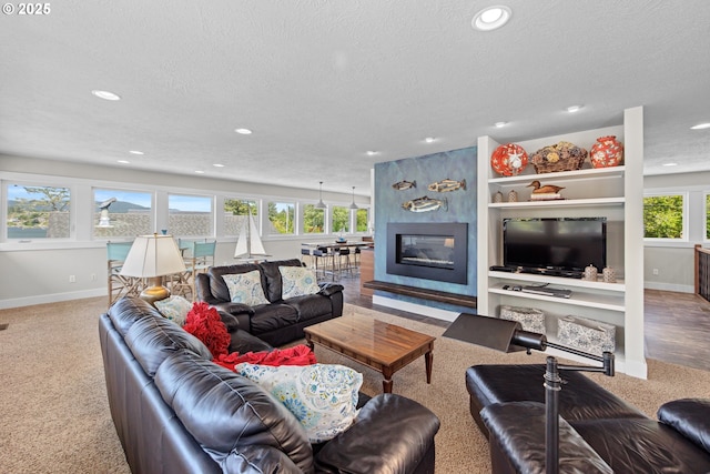 2941 NE Loop Dr, Otis, OR 97368 - carpeted living area featuring a textured ceiling, baseboards, recessed lighting, and a large fireplace