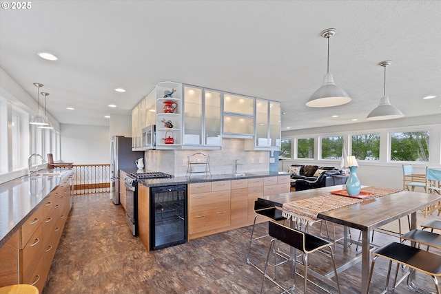2941 NE Loop Dr, Otis, OR 97368 - kitchen featuring stainless steel appliances, a sink, wine cooler, open shelves, and tasteful backsplash