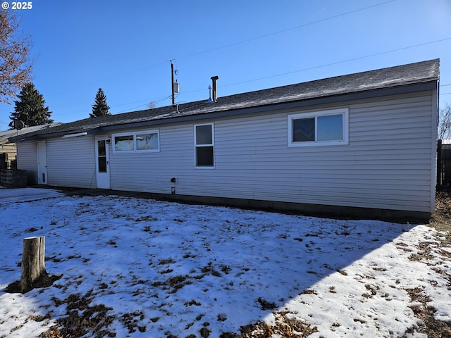 view of snow covered rear of property