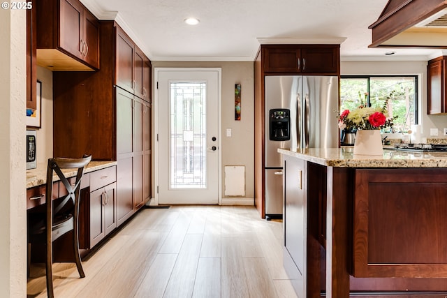 kitchen with stainless steel fridge with ice dispenser, light stone countertops, crown molding, light wood-style flooring, and recessed lighting