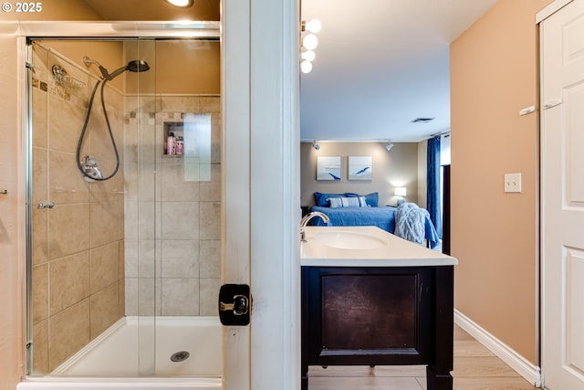 bathroom featuring ensuite bath, a shower stall, vanity, and wood finished floors