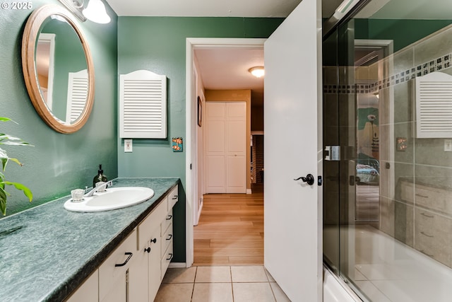 full bath featuring vanity, tile patterned floors, and shower / bath combination with glass door