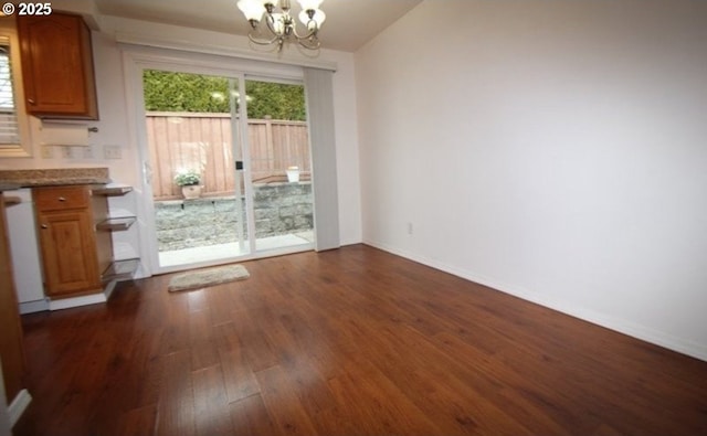 unfurnished dining area with an inviting chandelier and dark hardwood / wood-style flooring