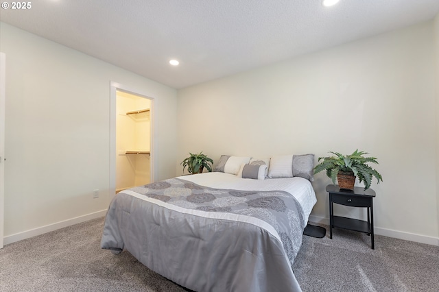 carpeted bedroom with a walk in closet and a closet