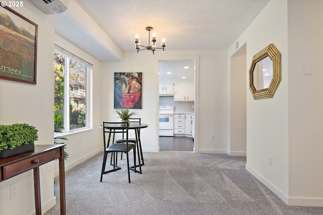 carpeted dining room featuring a wall unit AC, a textured ceiling, and a chandelier