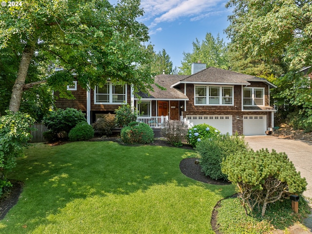 tri-level home with a garage, a front yard, and a porch