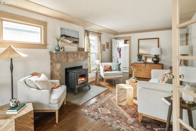 living area with plenty of natural light, wood-type flooring, and a wood stove