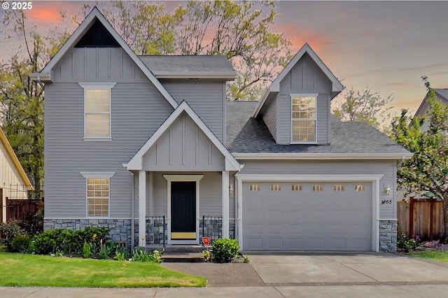 view of front facade with a garage, board and batten siding, stone siding, and concrete driveway