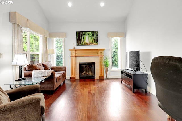 sitting room with a tiled fireplace, recessed lighting, dark wood-style flooring, and vaulted ceiling