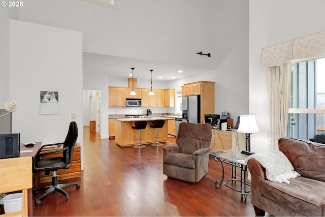 living room featuring recessed lighting, a high ceiling, and dark wood-style flooring
