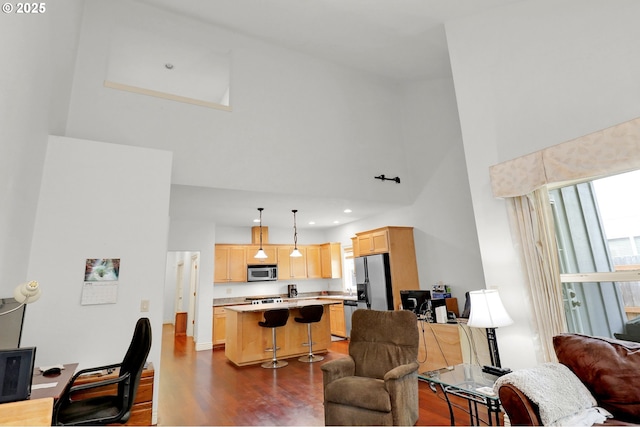 living room with recessed lighting, a high ceiling, and wood finished floors