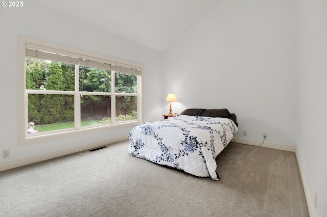 carpeted bedroom featuring baseboards, visible vents, and vaulted ceiling