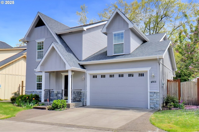 craftsman-style home featuring board and batten siding, roof with shingles, stone siding, and concrete driveway