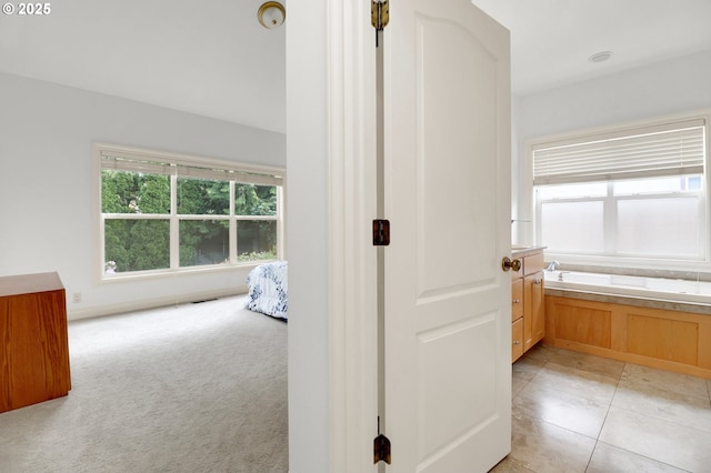hall featuring light colored carpet