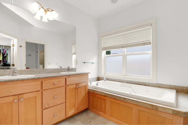 full bath with a sink, tile patterned floors, a garden tub, and double vanity