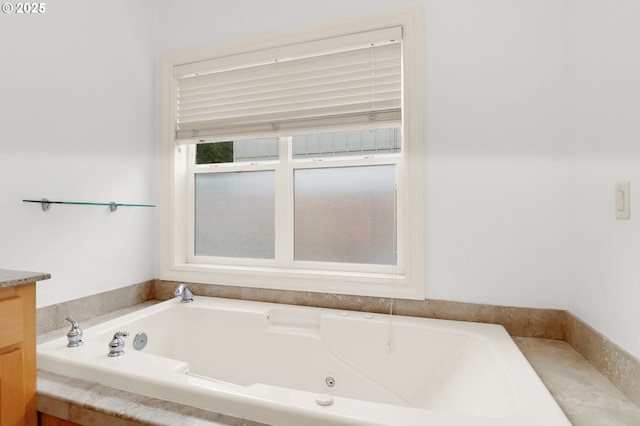 bathroom with a jetted tub and vanity