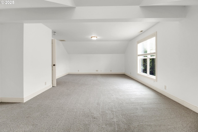 additional living space featuring baseboards, carpet, and vaulted ceiling