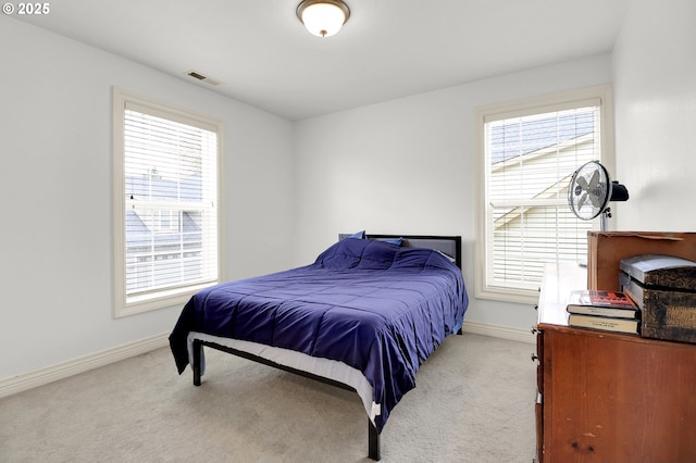carpeted bedroom featuring baseboards, multiple windows, and visible vents