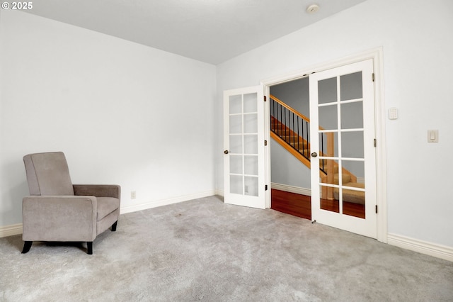 unfurnished room featuring french doors, baseboards, carpet floors, and stairway