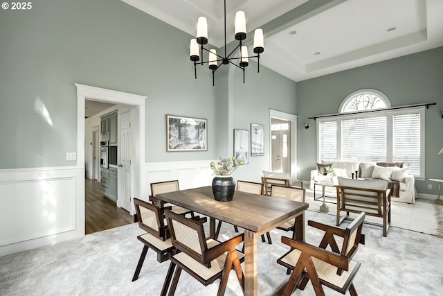14606 NW Applegate Ln, Portland, OR 97229 - dining room with a tray ceiling, a chandelier, a wainscoted wall, and a towering ceiling