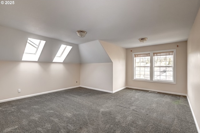 14606 NW Applegate Ln, Portland, OR 97229 - additional living space featuring dark colored carpet, baseboards, vaulted ceiling with skylight, and visible vents