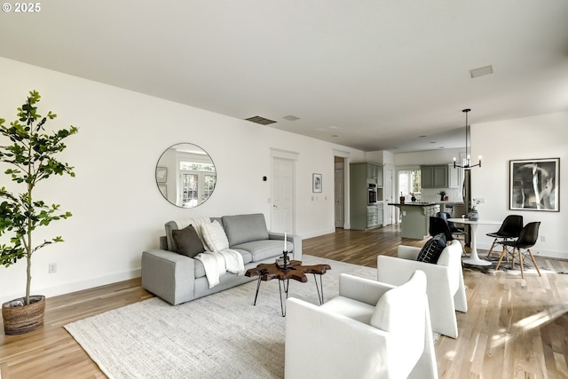 14606 NW Applegate Ln, Portland, OR 97229 - living room with light wood-style floors, baseboards, and a chandelier