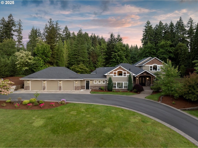 28800 SW Wildhaven Ln, Hillsboro, OR 97123 - view of front of home with an attached garage, stone siding, asphalt driveway, and a front yard