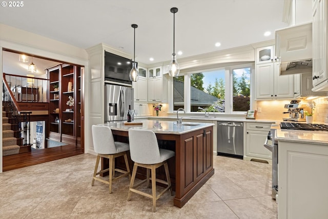 28800 SW Wildhaven Ln, Hillsboro, OR 97123 - kitchen with stainless steel appliances, backsplash, an island with sink, a sink, and glass insert cabinets
