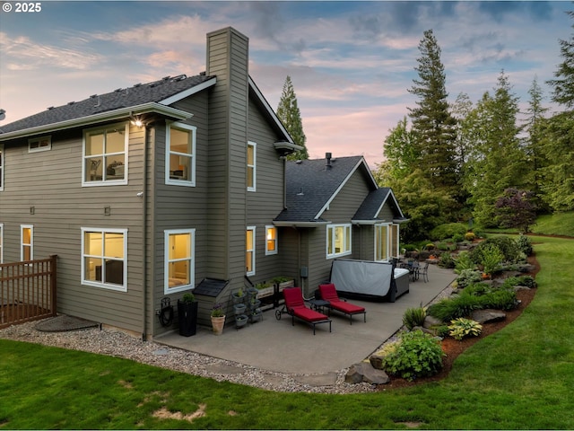 28800 SW Wildhaven Ln, Hillsboro, OR 97123 - back of property at dusk featuring a patio area, a chimney, a yard, and a shingled roof