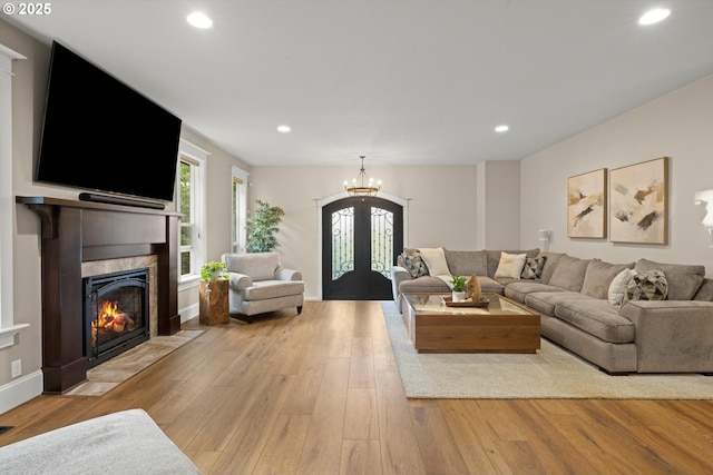 28800 SW Wildhaven Ln, Hillsboro, OR 97123 - living room featuring a tile fireplace, french doors, light wood-style flooring, recessed lighting, and a chandelier