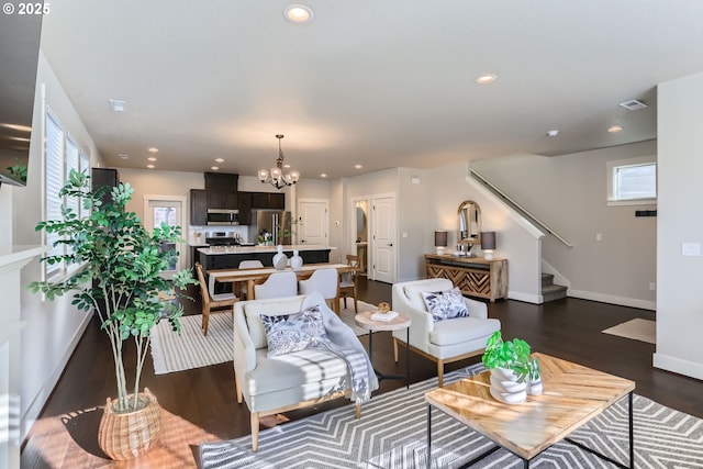 living room featuring a notable chandelier, dark hardwood / wood-style floors, and a wealth of natural light